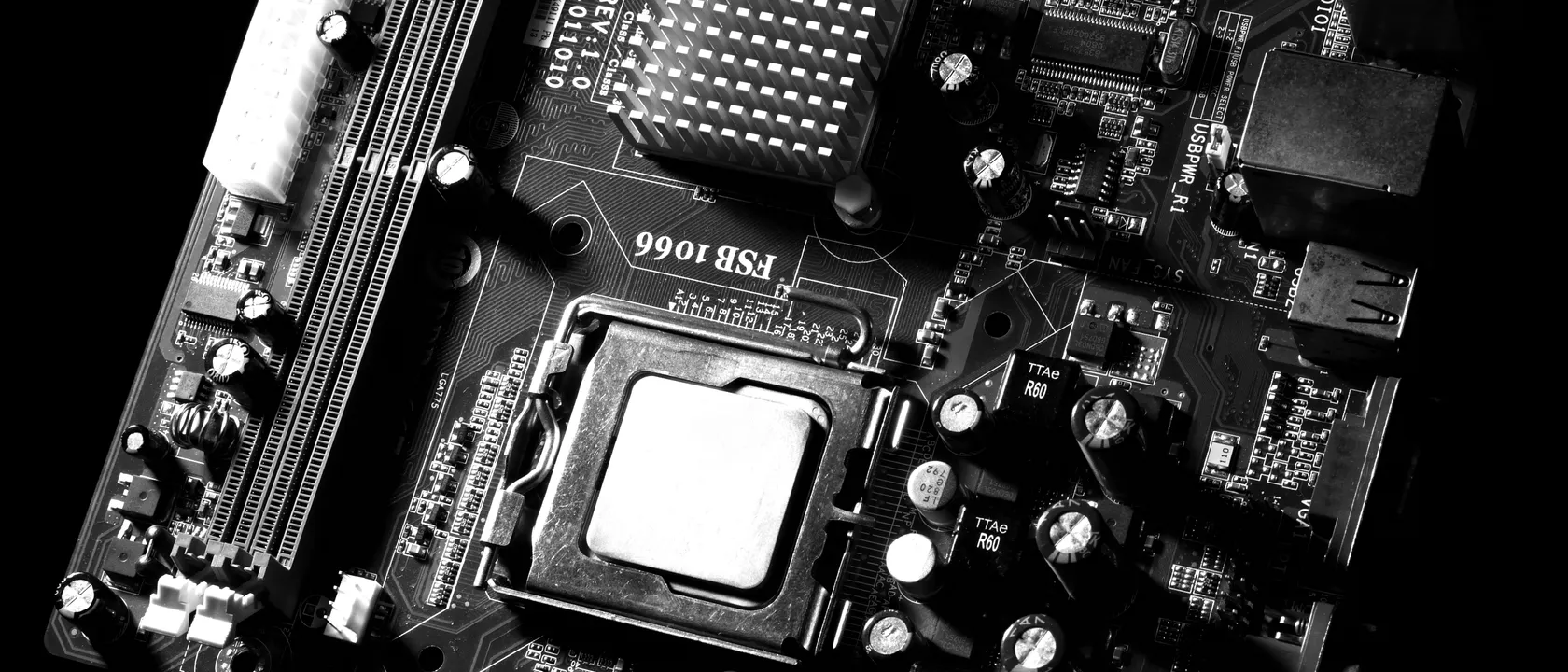 Close-up of a computer motherboard and processor socket in monochrome
